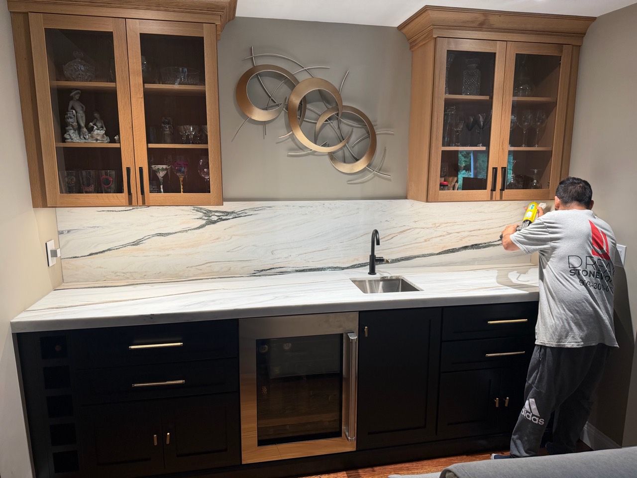 Dream Stoneworks team member installing a countertop backsplash at a Marlborough, Massachusetts home